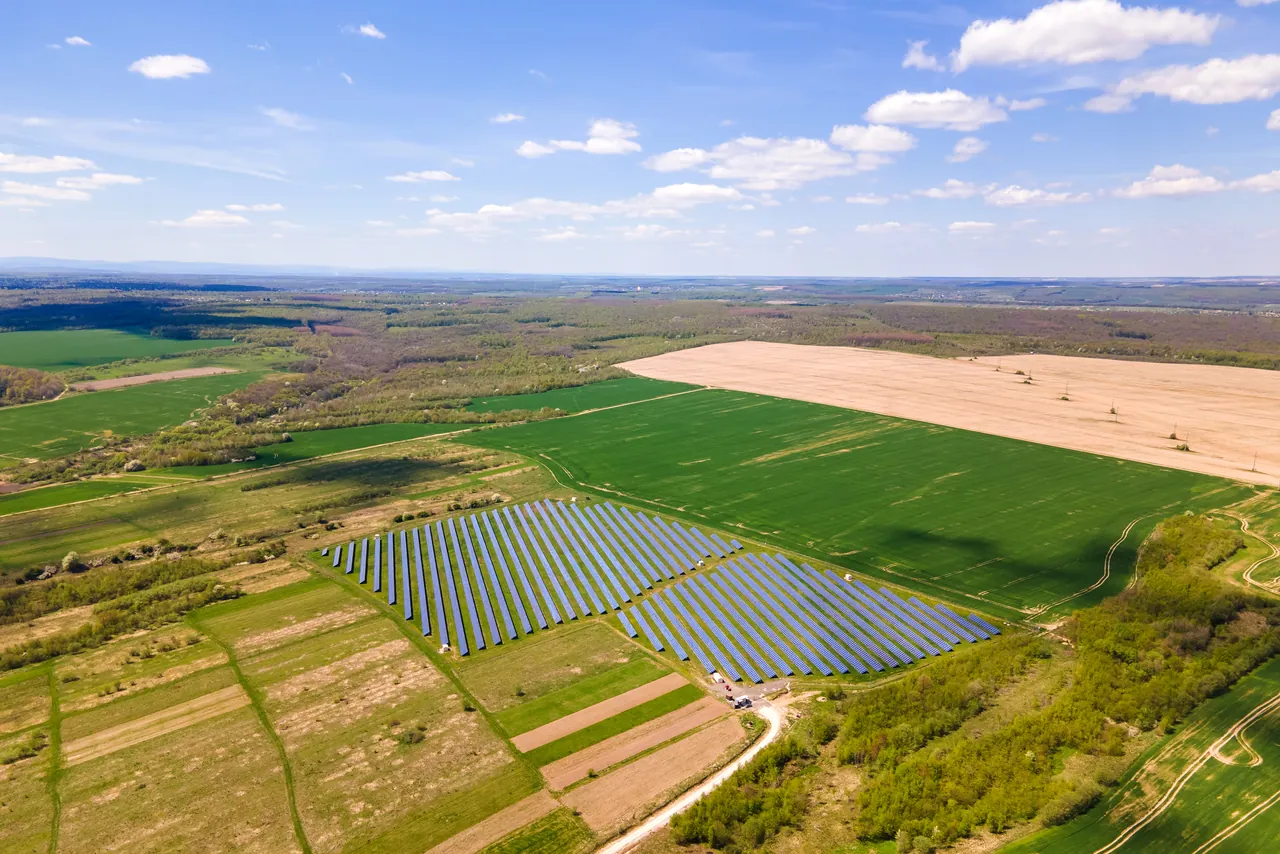 Widok z góry na farmę fotowoltaiczną wśród pól